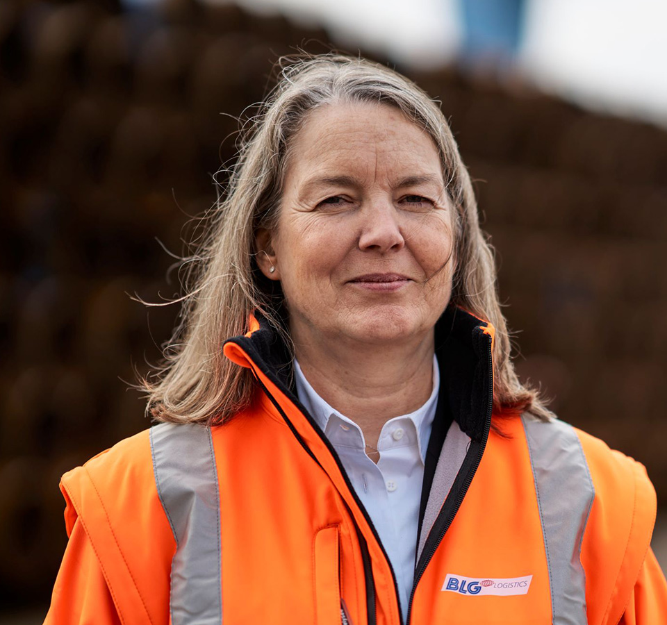 Einzelportrait Christine Hein in oranger Schutzjacke (Foto)