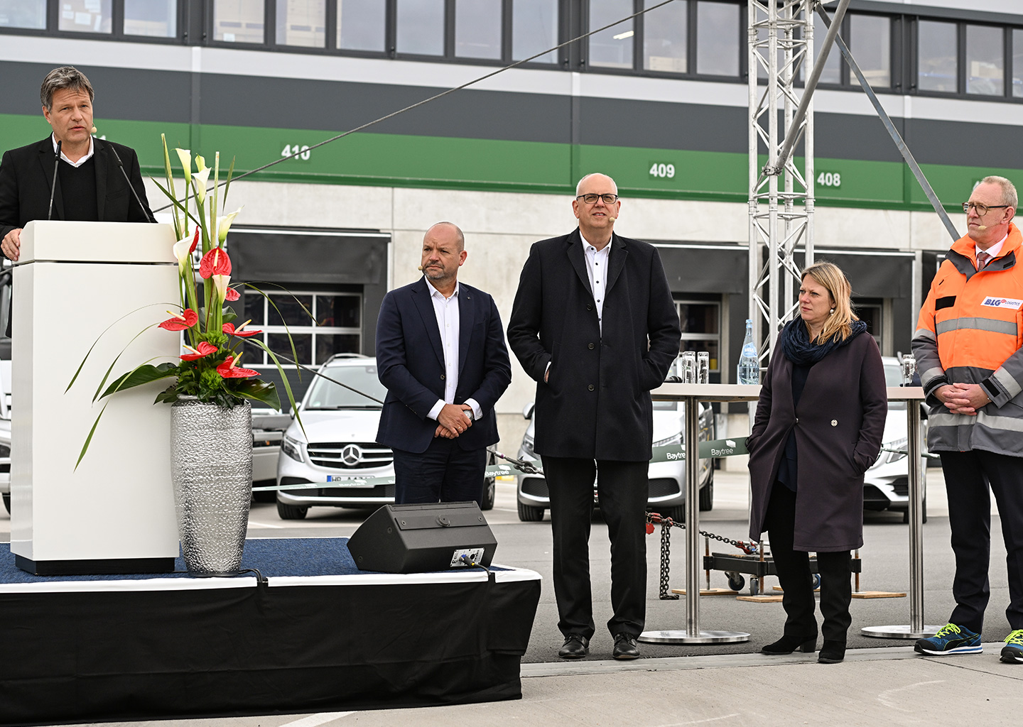 Bundesminister Robert Habeck hält eine Rede an einem Pult, Mitglieder des Vorstands sind ebenso zu sehen. (Foto)