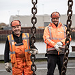 Two smiling men in orange saftey gear (Photo)