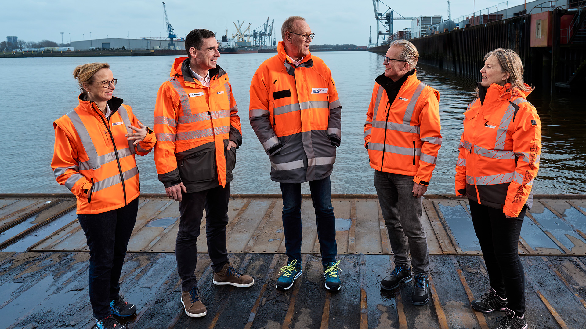 The members of the Executive Board in orange jackets at the harbor (Photo)