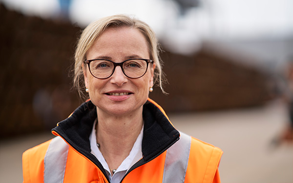 Individual Portrait of Ulrike Riedel in an orange safety jacket (Photo)