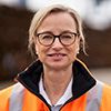 Individual Portrait of Ulrike Riedel in an orange safety jacket (Photo)