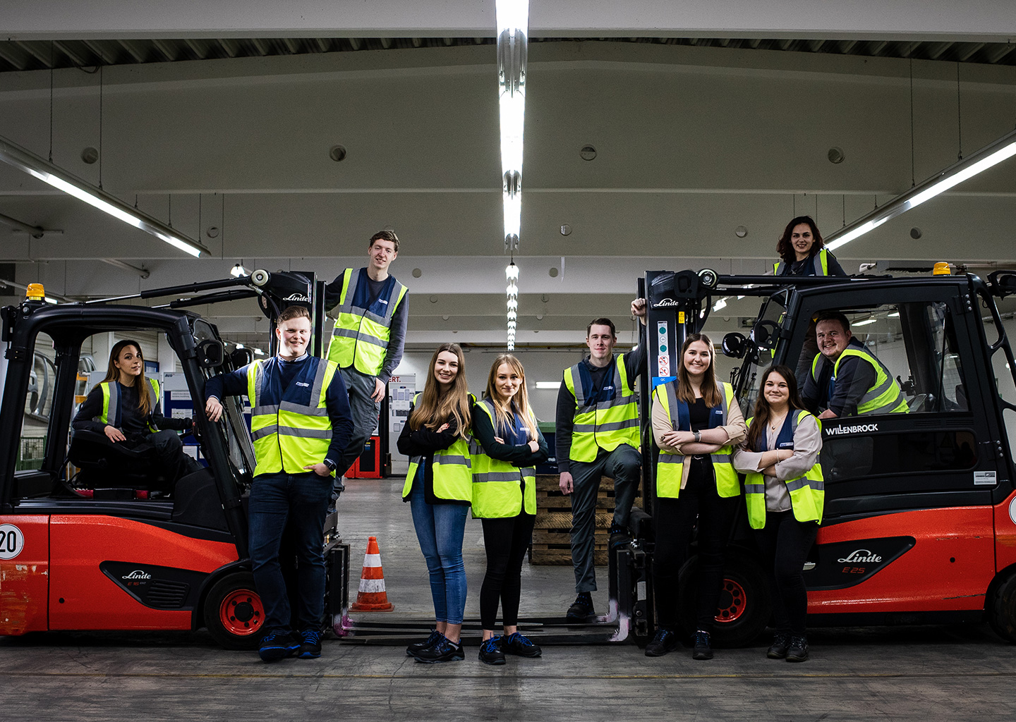 Young BLG employees pose next to two forklift trucks (Photo)