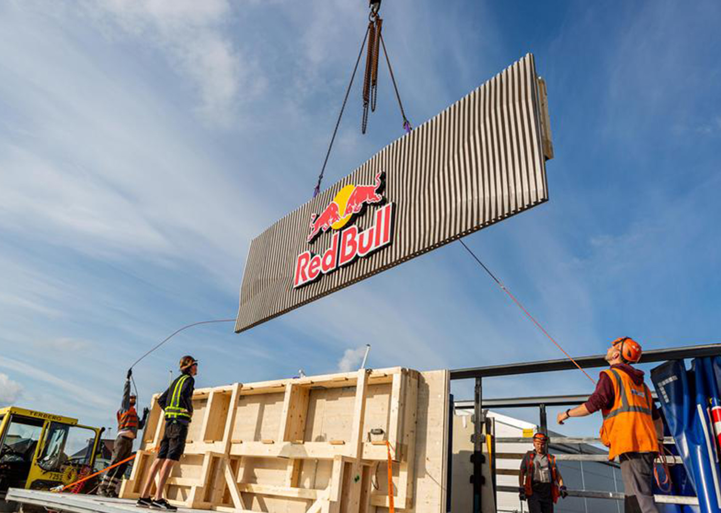 A large Redbull sign is lifted up with a crane (Photo)