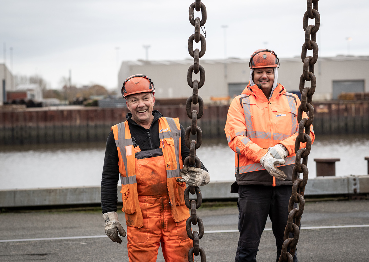 Two smiling men in orange protective suits (Photo)