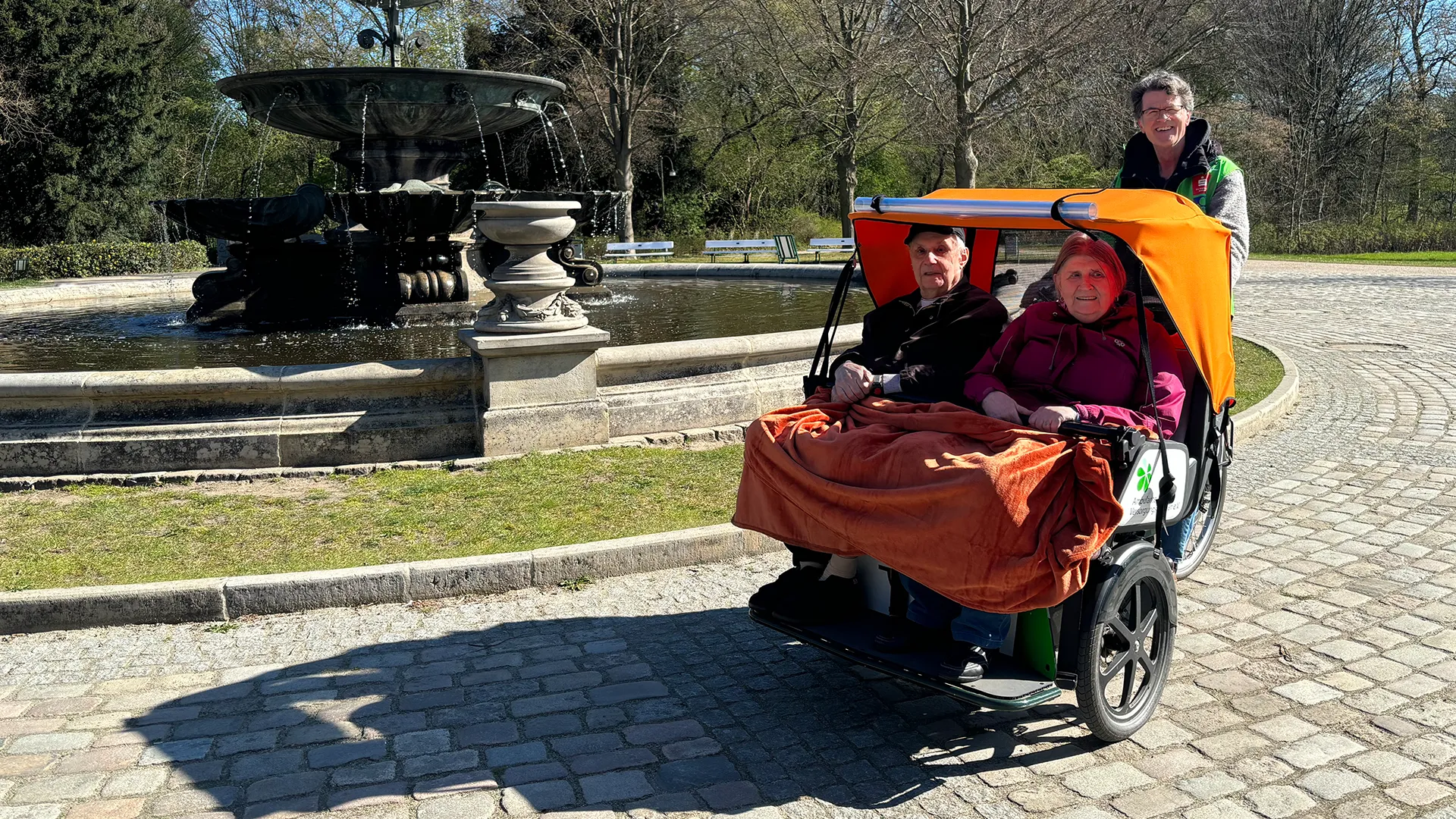 Senioren Paar in Transportfahrzeug blicken fröhlich in die Kamera (Foto)