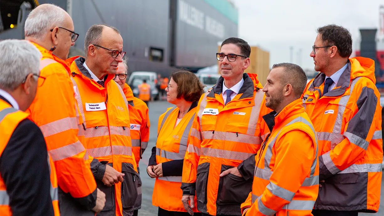 People at the harbor wearing orange vests communicating (Photo)