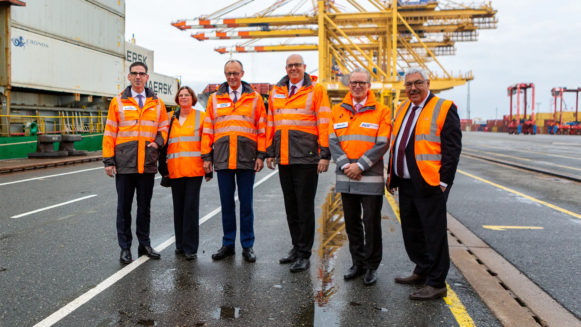Board members and Friedrich Merz at the harbor wearing orange vests (Photo)