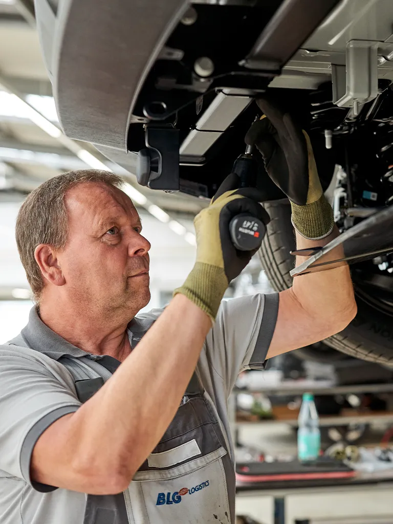 Mechanic working underneath a vehicle (Photo)